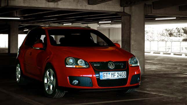 A photo of a red Golf GTI in a car park. 
