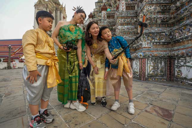 FILE - Chinese family tourists rent traditional Thai costumes and take selfies at Wat Arun, or the &quot;Temple of Dawn,&quot; in Bangkok, Thailand, on Jan. 12, 2023. Thailand&#39;s new cabinet has approved a temporary visa exemption for tourists from China and Kazakhstan in its first meeting on Wednesday, Sept. 13, for a bid to boost tourism and the economy. (AP Photo/Sakchai Lalit, File)