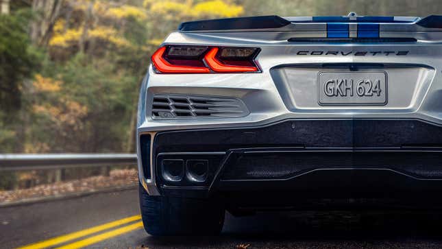 Rear view of the driver-side half of the 2024 Corvette E-Ray on a wooded road.
