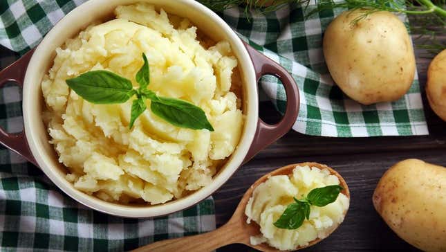 Bowl of mashed potatoes topped with large leaf