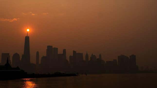 The sun rises behind the One World Trade Center, while the smoke from Canada wildfires covers the Manhattan borough as it is seen from Liberty State Park on June 8, 2023 in New Jersey.