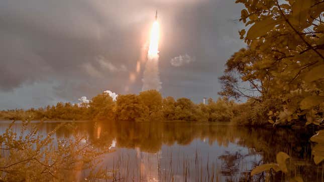 A space rocket launches over a lake