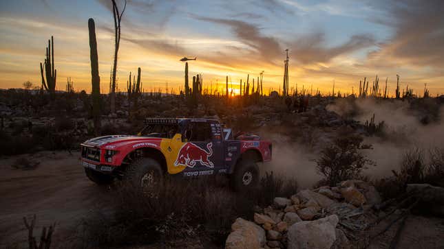 A photo of a Red Bull truck racing at sunset. 