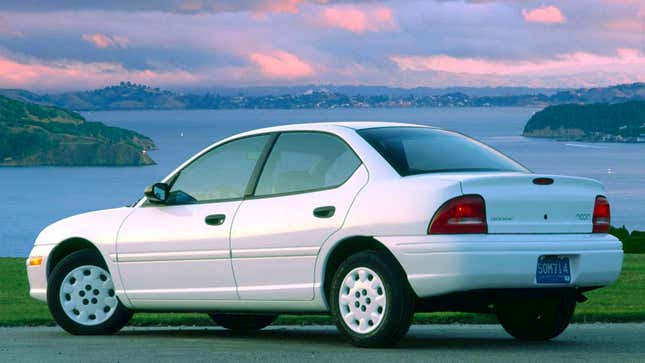 A photo of a white Dodge Neon sedan at sunset. 