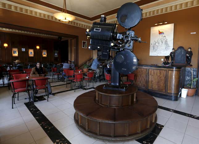 An old film projector stands inside the coffee shop in the foyer of the Roma Cinema.