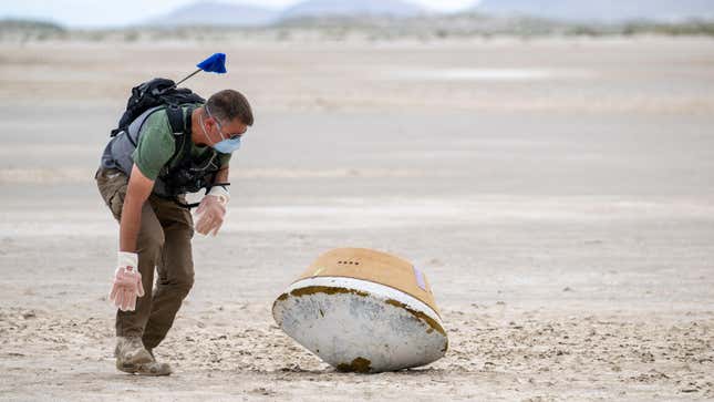 A military representative checks the mock sample capsule’s landing site for unexploded ordnance.