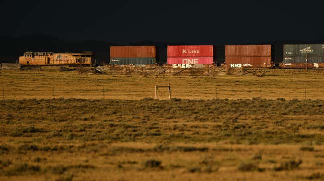 A Union Pacific freight train carries cargo shipping containers along a rail line at sunset in Bosler, Wyoming on August 13, 2022. 
