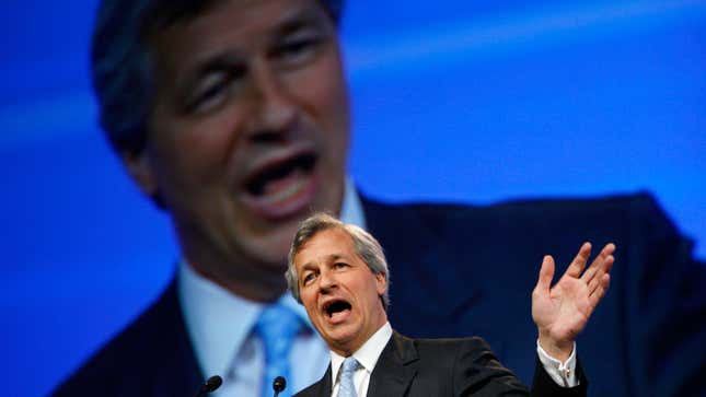 Jamie Dimon speaks at a podium with an image of his face on a giant screen behind him