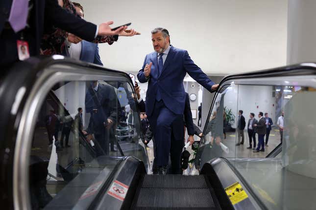 Ted Cruz on an escalator gesturing toward the camera.
