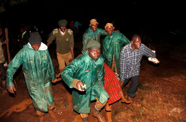 Members of the National Youth Service carry away a dead body covered in a blanket during the early hours of Thursday, May 10, 2018 near Solai, in Kenya's Rift Valley. Water burst through the banks of the Patel Dam in Nakuru County late Wednesday night after heavy rains, sweeping away hundreds of homes and killing dozens.