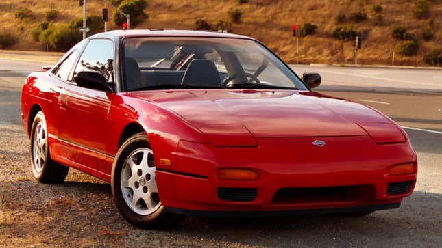 A photo of a red Nissan 240SX coupe. 
