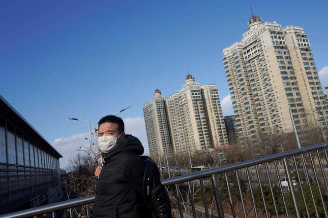 A man wearing a face mask walks on an overpass near a residential compound, as the country is hit by a novel coronavirus outbreak in Beijing, China March 1, 2020. REUTERS/Stringer – RC21BF98AB7S