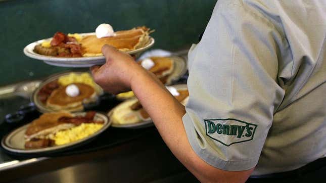 Denny's server holding plates of breakfast food