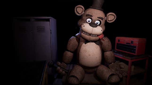 A creepy Freddy Fazbear animatronic sits in a dark room.
