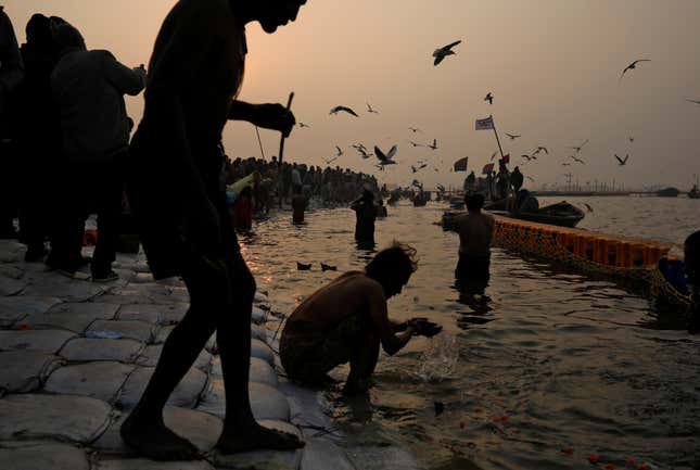 Devotees take a holy dip at Sangam, the confluence of the Ganga, Yamuna, and Saraswati rivers.