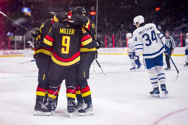 Mar 4, 2023; Vancouver, British Columbia, CAN; Vancouver Canucks forward J.T. Miller (9) celebrates with defenseman Kyle Burroughs (44) and forward Elias Pettersson (40) after scoring a goal against the Toronto Maple Leafs in the third period at Rogers Arena. Canucks won 4-1.