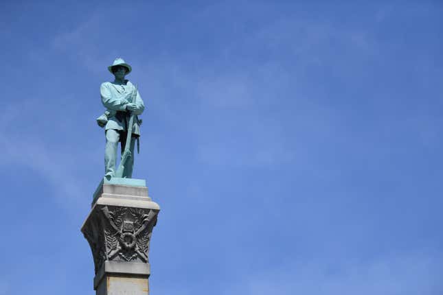 A statue of a Confederate soldier stands high above the crowd during a dedication ceremony in Brandenburg, Kentucky, U.S. May 29, 2017 for a Civil War Confederate Soldier Memorial recently removed from the campus of the University of Louisville. REUTERS/Bryan Woolston - RTX385EG