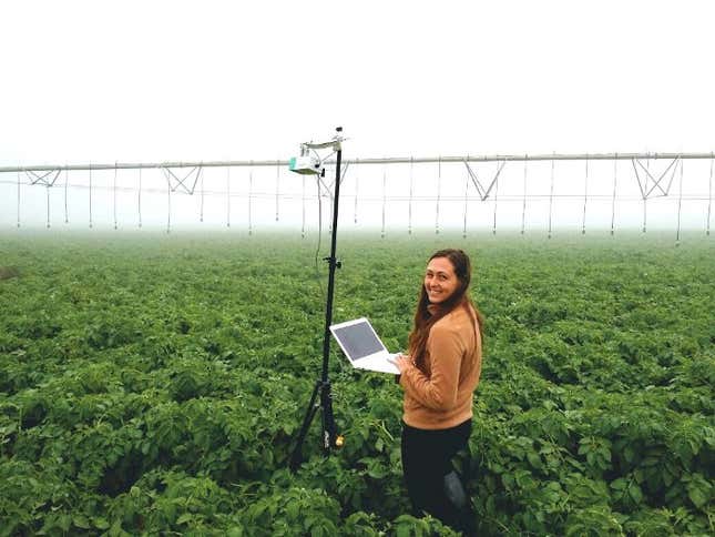 A Prospera scientist working with a camera mounted on a movable sprinkler system.