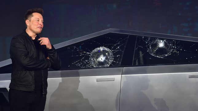 Tesla CEO Elon Musk stands next to a Cybertruck with broken windows after a demonstration gone wrong.
