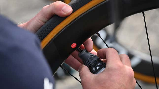 A person checks the pressure on a bike tire 