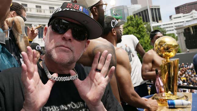 Denver Nuggets' coach Michael Malone is shows off a diamond choker while wearing a hat and sunglasses at the championship celebration parade in Denver.