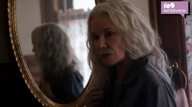 Barbara Hershey has long grey hair and is reflected in an oval mirror in a scene from The Manor.