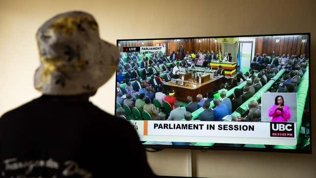A Ugandan transgender woman who was recently attacked and currently being sheltered watches a TV screen showing the live broadcast of the session from the Parliament for the anti-gay bill, at a local charity supporting the LGBTQ Community near Kampala on March 21, 2023. 