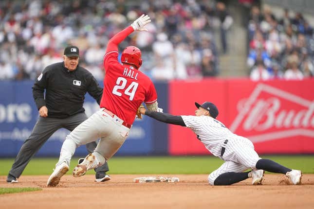 Apr 5, 2023; Bronx, New York, USA; New York Yankees shortstop Anthony Volpe (11) tags out Philadelphia Phillies first baseman Darick Hall (24) trying to stretch a single into a double during the fourth inning at Yankee Stadium.