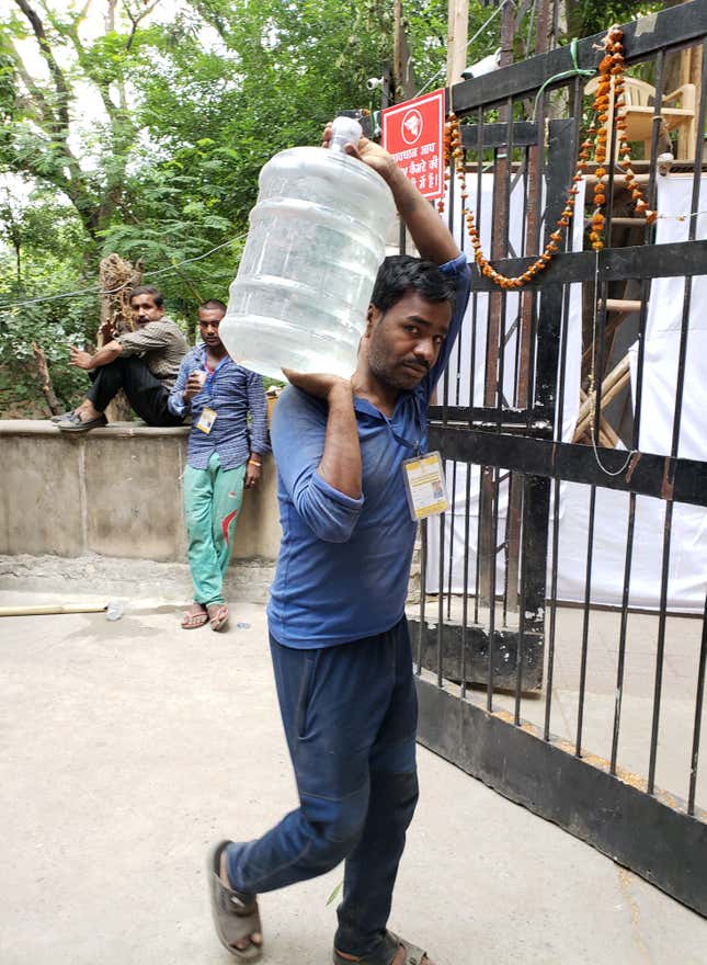 A worker brings water into the counting center for Delhi South.