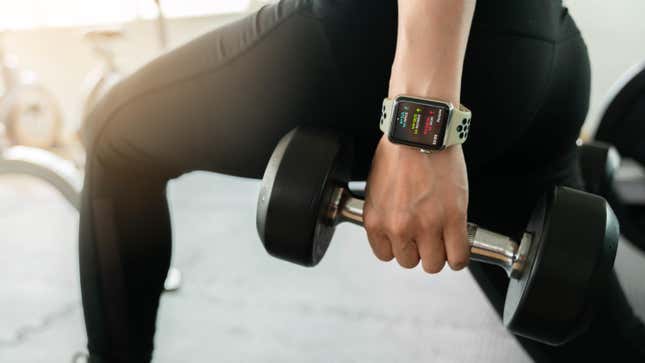A person lifting a hand weight while wearing an Apple Watch