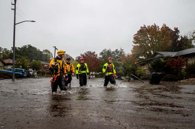 Firefighters check for residents trapped by floodwaters on Brookhaven Drive in Santa Rosa, California.