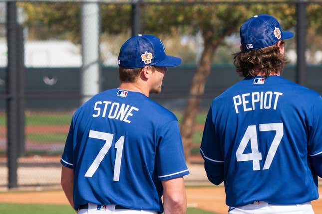 Feb 18, 2023; Glendale, AZ, USA; Los Angeles Dodgers pitchers Gavin Stone (71) and Ryan Pepiot (47) warm up during a spring training workout at Camelback Ranch.
