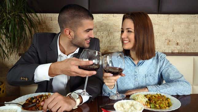 Couple sits on same side of table at restaurant
