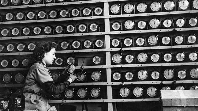 A woman winds clocks in a clock shop.