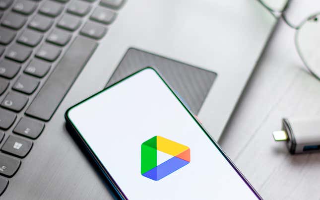 El logotipo de Google Drive en la pantalla de un móvil sobre un portátil Windows.