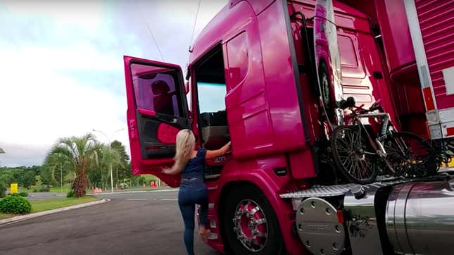 Screenshot of driver climbing into her pink truck