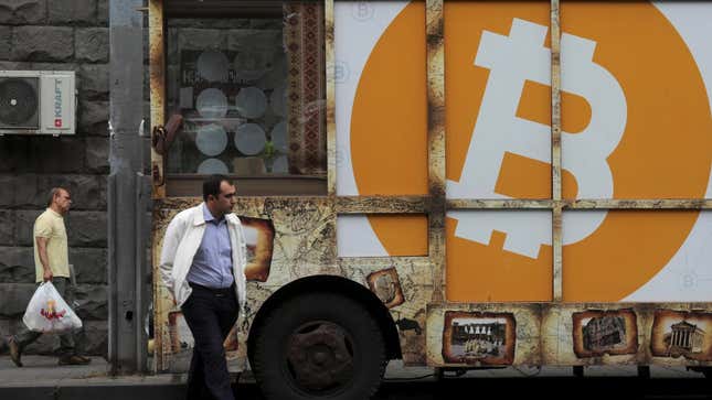 A man in India standing in front of a Bitcoin sign.