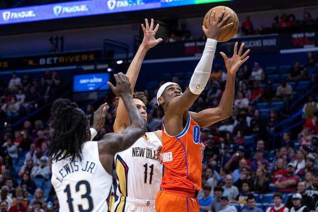 Mar 11, 2023; New Orleans, Louisiana, USA; Oklahoma City Thunder guard Shai Gilgeous-Alexander (2) drives to the basket against New Orleans Pelicans guard Dyson Daniels (11) and guard Kira Lewis Jr. (13) during the first half at Smoothie King Center.