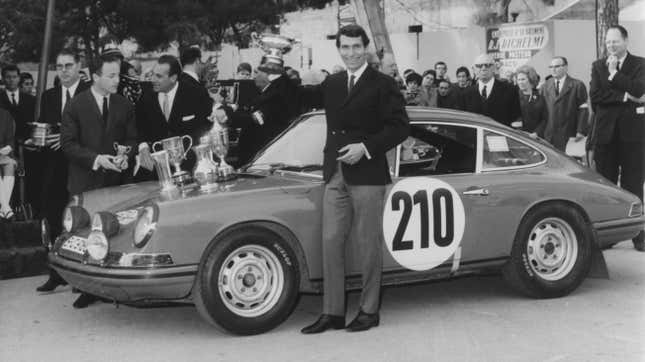 Vic Elford of Great Britain holds aloft the trophy as he stands beside the #210 Porsche 911T after winning the Monte Carlo Rally on 25 Jan 1968 in the Principality of Monaco in Monte Carlo, Monaco