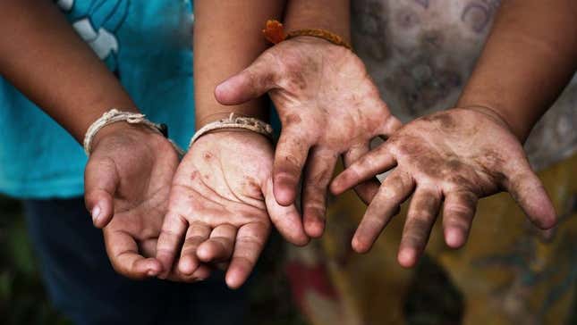 Children showing their hands caked in dirt.