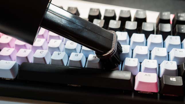 A photo of a vacuum nozzle running over a keyboard