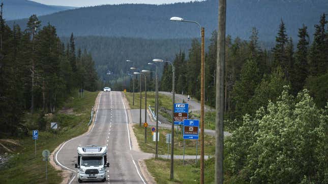 A photo of an RV driving down a road in Finland. 