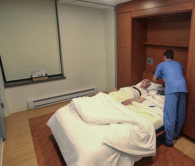 A technician prepares equipment to monitor a patient's brain activity during a sleep study