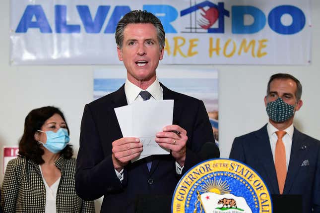 California’s Governor Gavin Newsom, flanked by Los Angeles Mayor Eric Garcetti (R), displays the seven bills signed as he joins city leaders in celebration of legislation to support the state’s expansion of mental health services and behavioral health housing as part of California’s package to address the homeless crisis in Los Angeles, California on September 29, 2021.