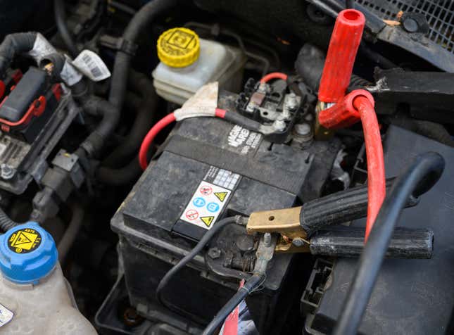 Jumper cables are jammed to a car battery. 
