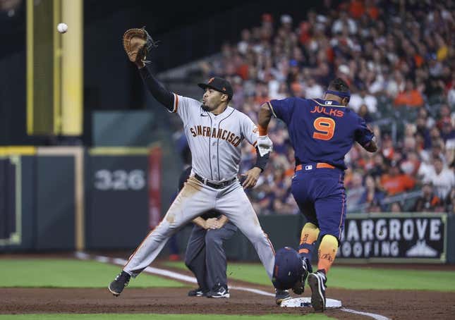 May 1, 2023; Houston, Texas, USA; Houston Astros left fielder Corey Julks (9) is out at first base as San Francisco Giants first baseman LaMonte Wade Jr. (31) fields a throw during the second inning at Minute Maid Park.