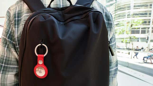 A male teenager with an AirTag visible attached to his backpack