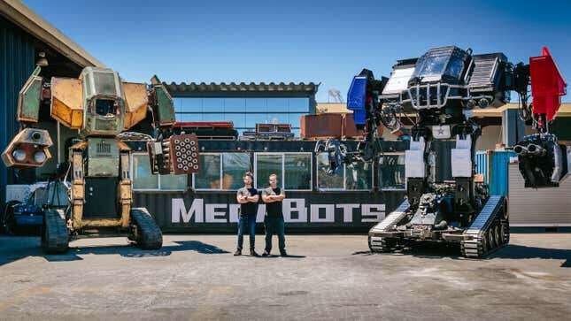 Oehrlein and Cavalcanti standing rather proudly between their old and new robots.