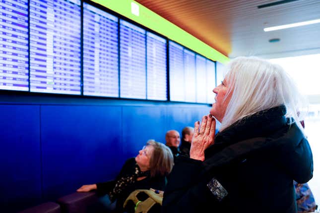 Cathi Vinson looks at a departures board at Denver International Airport showing canceled flights during a winter storm on February 22, 2023.