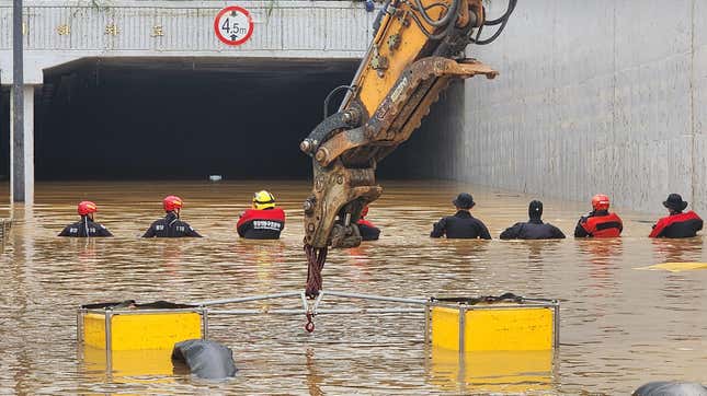 In this handout image provided by the South Korea National Fire Agency, South Korean rescue workers searching for missing persons along a road submerged by floodwaters leading to an underground tunnel in flood waters after heavy rains on July 16, 2023 in Cheongju, South Korea. Flooding and landslides caused by heavy rains have killed at least 32 people nationwide and left more than 10 people missing while thousands evacuated their homes due to rain damage, authorities said. 